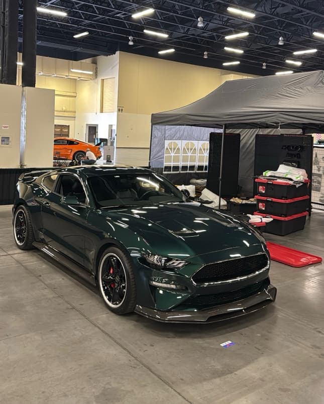 Dark green Ford Mustang Bullitt with full carbon fiber body kit on display at an Oklahoma car show
