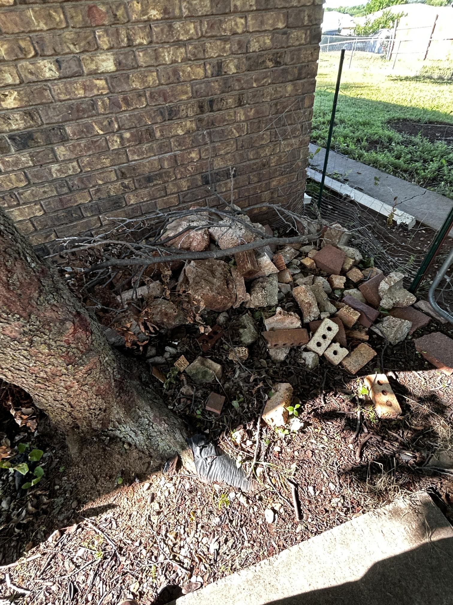 Concrete and brick debris pile beside house before removal